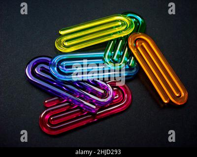 Acrylic paper clips on black background Stock Photo