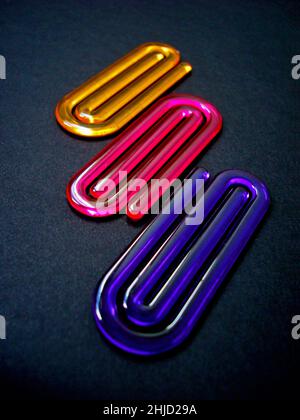 Acrylic paper clips on black background Stock Photo