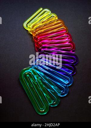 Acrylic paper clips on black background Stock Photo