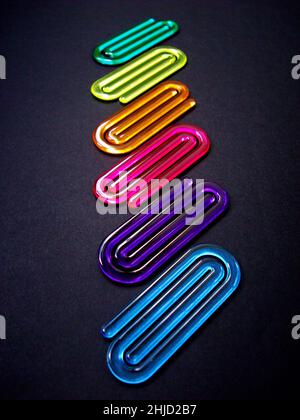 Acrylic paper clips on black background Stock Photo