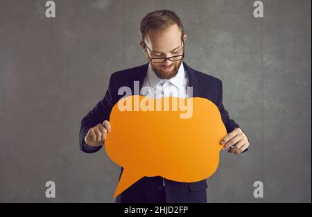 Portrait of happy young Caucasian male holding blank speech bubble. Stock Photo