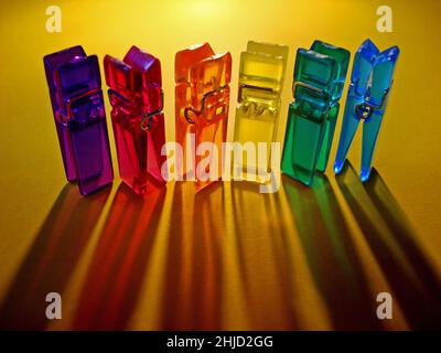 Acrylic color clothes pegs on yellow Stock Photo