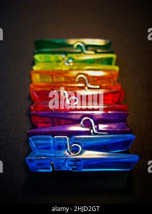 Acrylic color clothes pegs on black Stock Photo