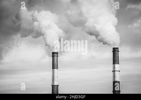 Closeup view steam coming out of pipes of thermoelectric power station in winter time.Termal power industry and environmental pollution concept, black Stock Photo