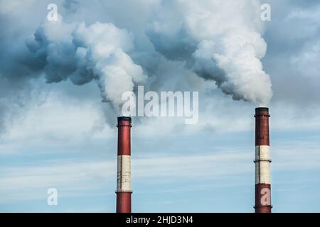 Closeup view steam coming out of pipes of thermoelectric power station in winter time.Termal power industry and environmental pollution concept and . Stock Photo