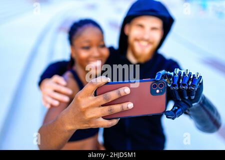 mixed race friends fitness training together outdoors taking selfie photo on smartphone camera Stock Photo