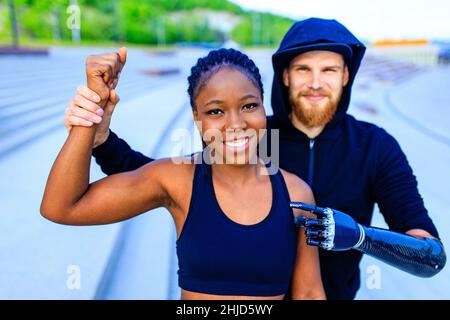 smiling young mixed race couple in sportswear warming up outdoors sity background early morning Stock Photo