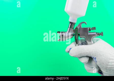 Manual and paint spray gun at work on background. Stock Photo