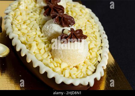 Brazilian easter egg stuffed with white granulated chocolate and cream, tasted with a spoon. Easter tradition in Brazil Stock Photo