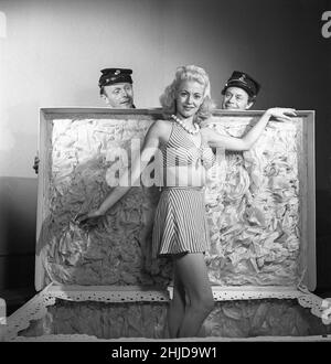 Girl in a surprise package. Two soldiers having opened a large present package finds a young blond woman in it. A scene from the swedish film 91:an Karlssons permis from 1947 with actors Irene Söderblom, Gus Dahlström and Holger Höglund. Sweden 1947 ref AE20-7 Stock Photo