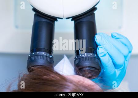 Professional female scientist doing experiment with electronic microscope in scientific genetic research laboratory Stock Photo