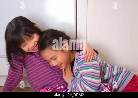 Two five year old girls hugging, friends since infancy Stock Photo