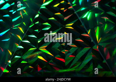 Abstract green and red grainy background with light triangles on black background. Stock Photo