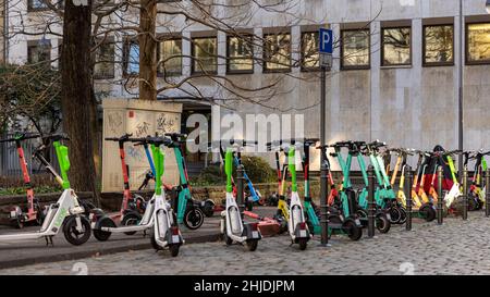 Electric push scooters waiting for users in Cologne Old town on a winter day Stock Photo