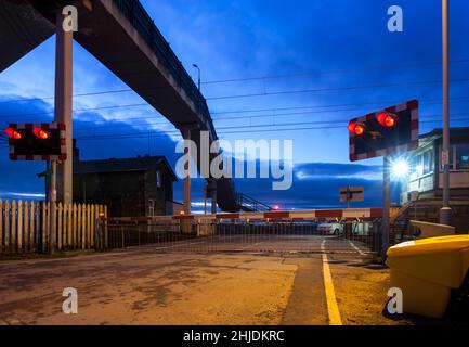 Hest Bank Level crossing with barriers and flashing lights on the west coast mainline, Lancashire UK Stock Photo