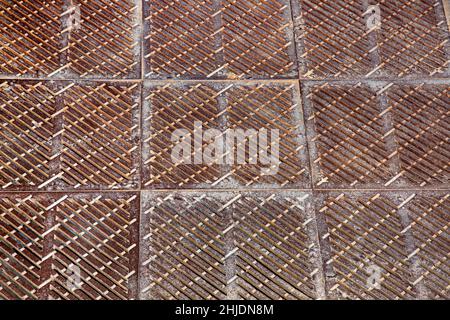 old rusty square shaped drainage grate, the surface of the storm system on the floor close-up. Stock Photo