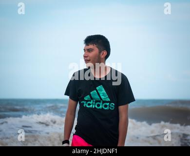 Palomino, Dibulla, La Guajira, Colombia - December 4 2021: A Young Latin Man Walks in the Beach Stock Photo