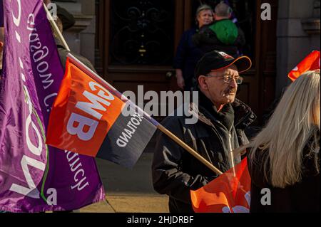 Glasgow, UK. 27th Jan, 2022. A member of the workers union GMB Scotland is seen holding a flag during the protest.Following the October 23rd protest in 2018, female employees of Glasgow City Council are still having issues with receiving the money owed to them, with some even saying the council is refusing to pay up, the payout tops £500m. (Photo by Stewart Kirby/SOPA Images/Sipa USA) Credit: Sipa USA/Alamy Live News Stock Photo