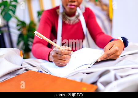 tanzanian woman with snake print turban over hear working in fashion house Stock Photo