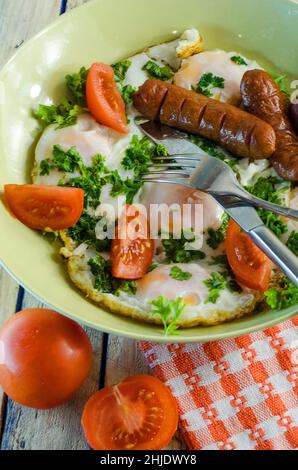 Breakfast - scrambled eggs with tomatoes and greens and sausage Stock Photo