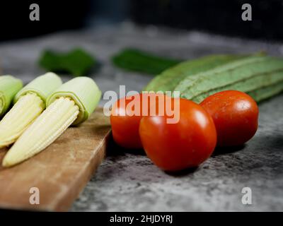 tomatoes on and vegetables on the table. Stock Photo