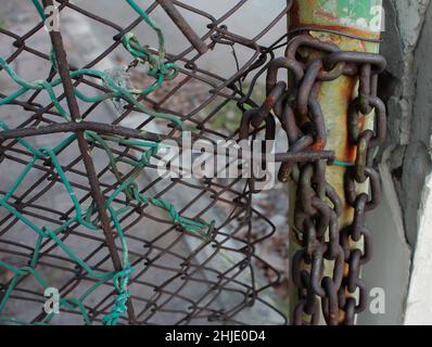 rivate property sign hangs on a metal fence. Gate is locked close with a chain and several padlocks. Stock Photo