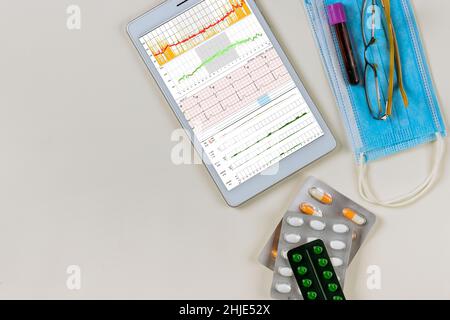 Medicall office report of cardiology patient with electrocardiogram heart in showing in digital tablet and pills Stock Photo