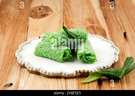 Dadar Gulung or Sweet Coconut Pancake, Indonesian Snack Dessert made from Flour with Sweetened Grated Coconut. Green COlor from Pandan and Suji Leaves Stock Photo