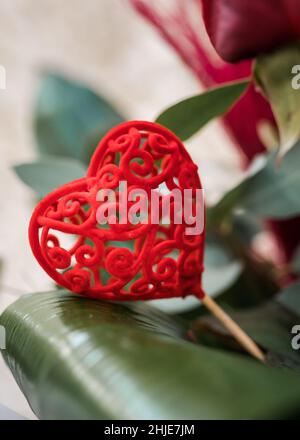 Stunning red valentines day love heart decoration in bunch of flowers for gift to loved one. Ornate shape on stick bright colourful design. Stock Photo