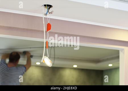 Repair of ceiling lamp. Working scene. Stock Photo