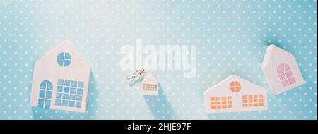 White toy houses on a blue with white polka dot background Stock Photo