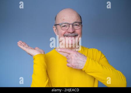 Senior man pointing with index finger to important information on copyspace Stock Photo
