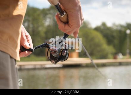 Male hands of a fisherman are holding a spinning closeup. Concept
