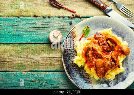 Appetizing beef stroganoff meat. Meat with mushrooms and mashed potatoes. Space for text, recipe place Stock Photo