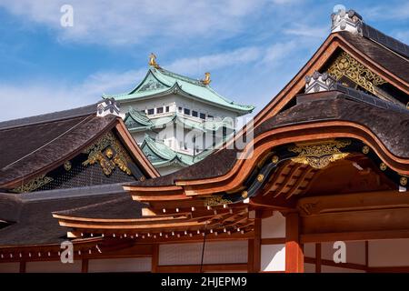 The view of the roof of Hommaru Palace which was destroyed by fire and reconstructed and the main keep of Nagoya castle on the background. Nagoya. Jap Stock Photo