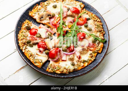 Pizza with salami, cheese, tomato on a pumpkin flatbread. Autumn recipe Stock Photo