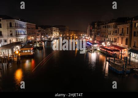 Venice, Italy - January 3 2022: Grand Canal or Canal Grande on a Dark Winter Night at Rialto Vaporetto Station Stock Photo