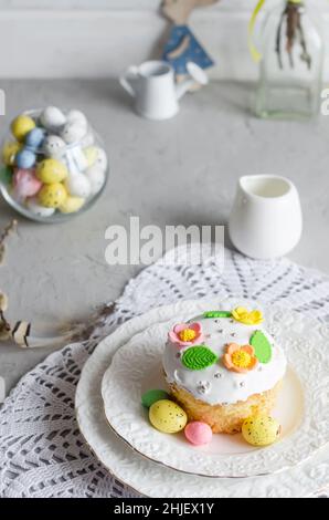 Place setting for Easter on the bright background with Easter cake with colorful topping, Decorative eggs sweets and holiday decorations Stock Photo