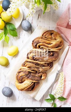 Easter baking. Homemade Easter Chocolate babka or brioche bread. Sweet yeast dough with chocolate filling and accompanied and nuts on a wooden table. Stock Photo