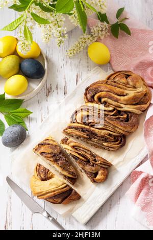 Easter baking. Homemade Easter Chocolate babka or brioche bread. Sweet yeast dough with chocolate filling and accompanied and nuts on a wooden table. Stock Photo