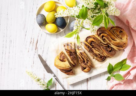 Easter baking. Homemade Easter Chocolate babka or brioche bread. Sweet yeast dough with chocolate filling and accompanied and nuts on a wooden table. Stock Photo