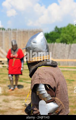 Two knights in armor before the battle, reconstruction of a jousting tournament. Holiday Ivan Kupala, Slavic traditions. faces are not visible. Stock Photo