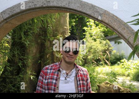 A closeup of a young man in glasses posing for the photo Stock Photo