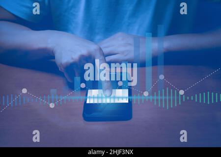 Man touching cell phone with digital business hologram graph finance chart. Stock Photo