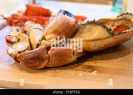 Whole English cooked fresh crab, Cancer pagurus,edible crab or brown crab, laying on a wooden chopping board in the process of being dressed Stock Photo