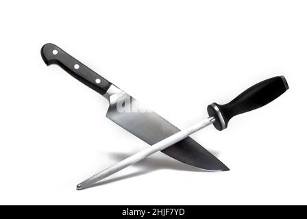 Close up of a high quality large sharp meat kitchen knife crossed with a long grinding stick both with black handle on white background concept for kn Stock Photo
