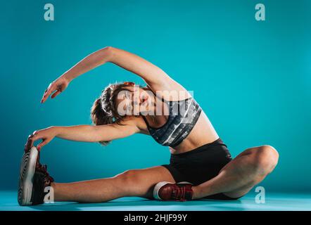 Fitness, sport, training, gym and wellness. Woman doing stretching excercises in a club Stock Photo