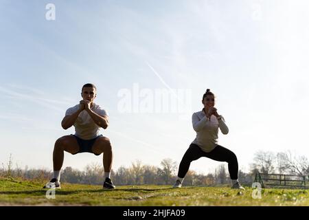 Two amazing and attractive fit friends are doing squad exercise Stock Photo