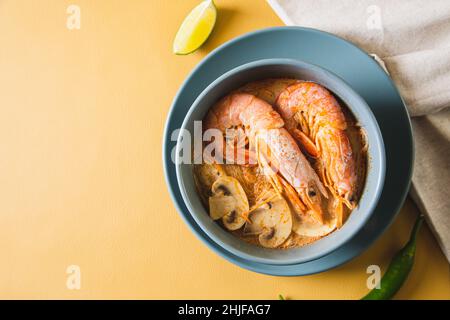 Tom Yum Goong Spicy Sour Soup on trendy table top view, Thai local food Stock Photo