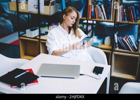 Focused woman using tablet in workspace Stock Photo